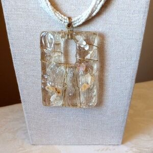 Multi strand white bead necklace with seashell acrylic pendant